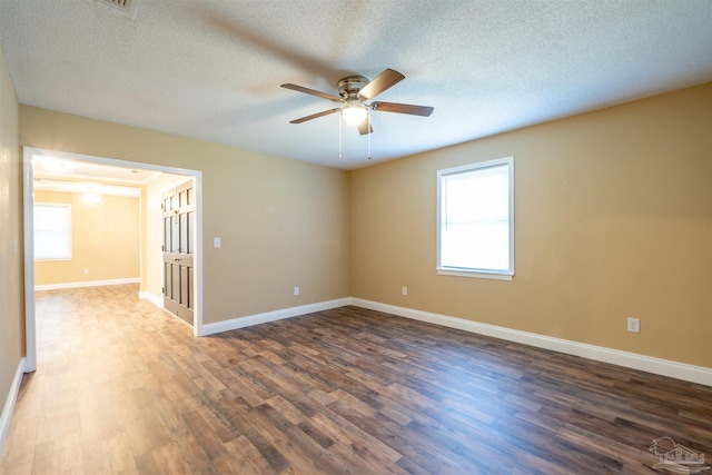 unfurnished room featuring a textured ceiling, dark hardwood / wood-style floors, and ceiling fan