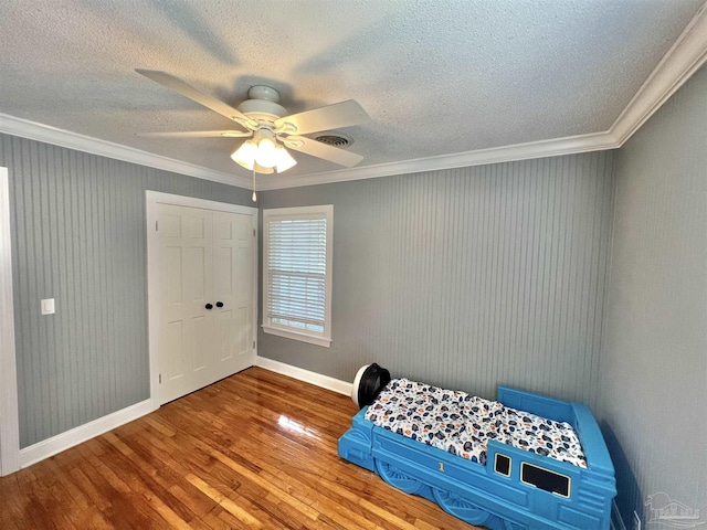 704 E Horner St, Atmore, AL 36502 - bedroom with wood finished floors, baseboards, ornamental molding, a textured ceiling, and a ceiling fan