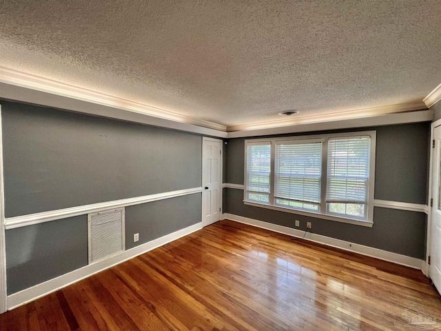 704 E Horner St, Atmore, AL 36502 - empty room with a textured ceiling, crown molding, wood finished floors, and baseboards