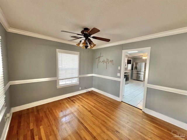 704 E Horner St, Atmore, AL 36502 - spare room featuring ceiling fan, wood finished floors, baseboards, ornamental molding, and a textured ceiling