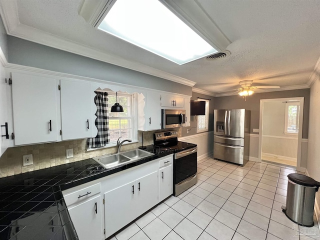 704 E Horner St, Atmore, AL 36502 - kitchen with stainless steel appliances, a sink, decorative backsplash, light tile patterned floors, and ornamental molding