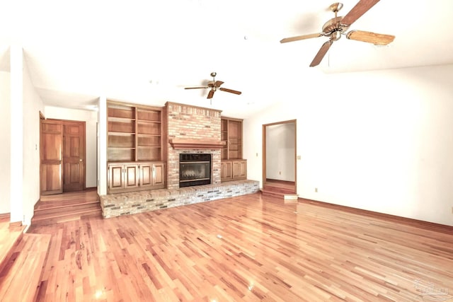 unfurnished living room with light hardwood / wood-style flooring, vaulted ceiling, ceiling fan, and a brick fireplace