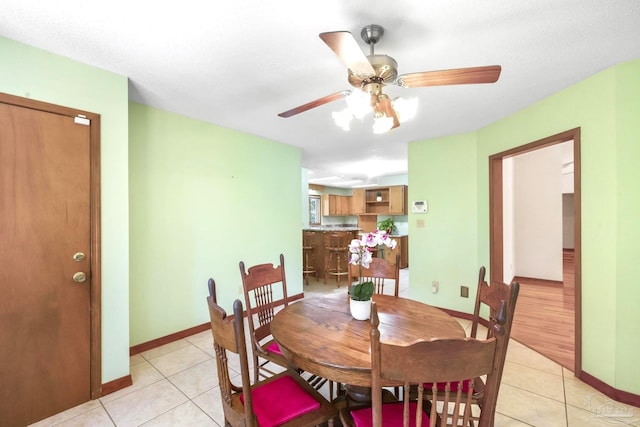 dining space with ceiling fan, a textured ceiling, and light tile patterned floors