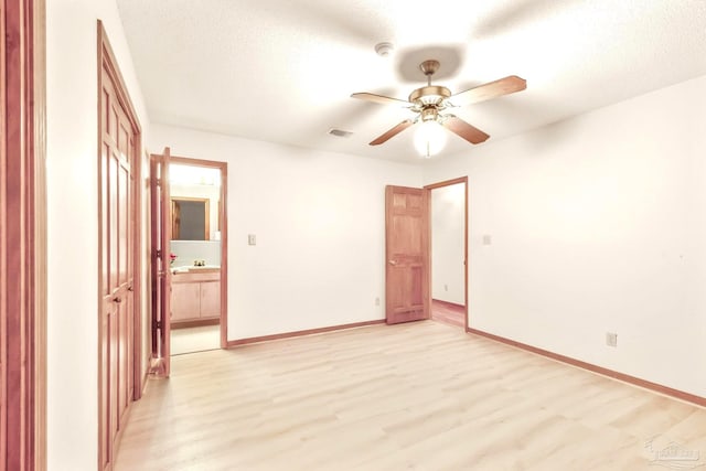 spare room with light hardwood / wood-style floors, ceiling fan, sink, and a textured ceiling