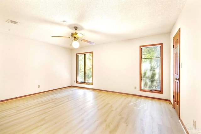 unfurnished room featuring ceiling fan, a textured ceiling, light hardwood / wood-style flooring, and plenty of natural light