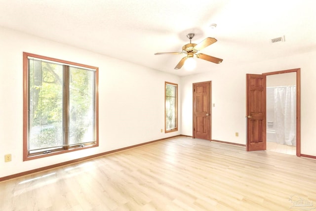 empty room with light wood-type flooring, a healthy amount of sunlight, and ceiling fan