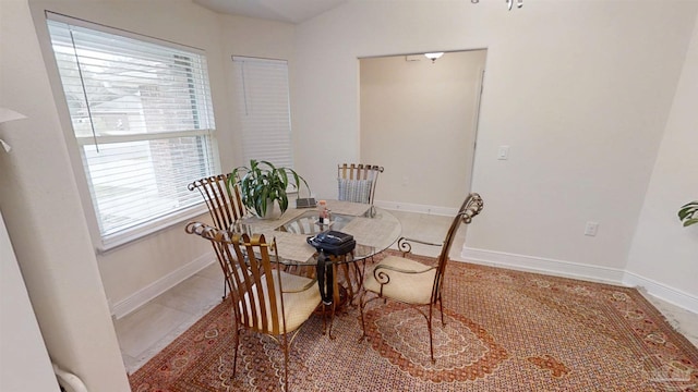 tiled dining space featuring baseboards