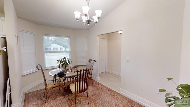 dining area with lofted ceiling, an inviting chandelier, light tile patterned floors, and baseboards