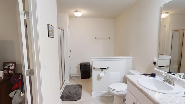 bathroom with toilet, a shower stall, vanity, and tile patterned floors