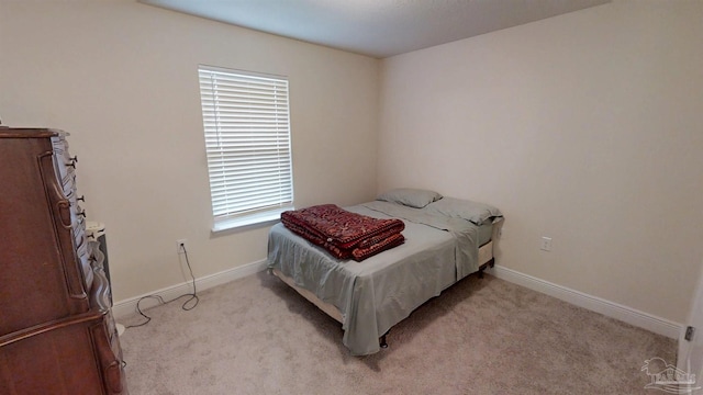 bedroom featuring baseboards and light colored carpet