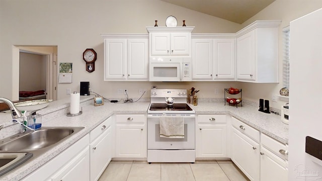 kitchen featuring white appliances, light tile patterned floors, white cabinets, vaulted ceiling, and a sink