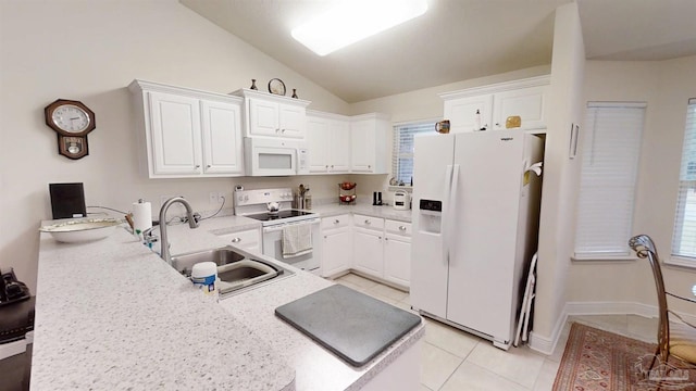 kitchen featuring lofted ceiling, a peninsula, white appliances, a sink, and white cabinets