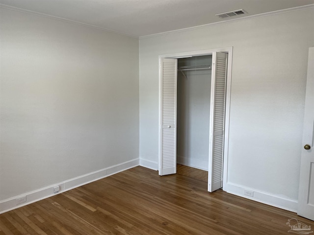 803 Pickens Ave, Pensacola, FL 32503 - unfurnished bedroom featuring dark wood finished floors, crown molding, baseboards, and a closet
