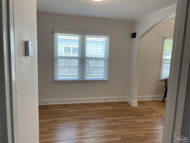 803 Pickens Ave, Pensacola, FL 32503 - empty room featuring arched walkways, wood finished floors, ornamental molding, and baseboards