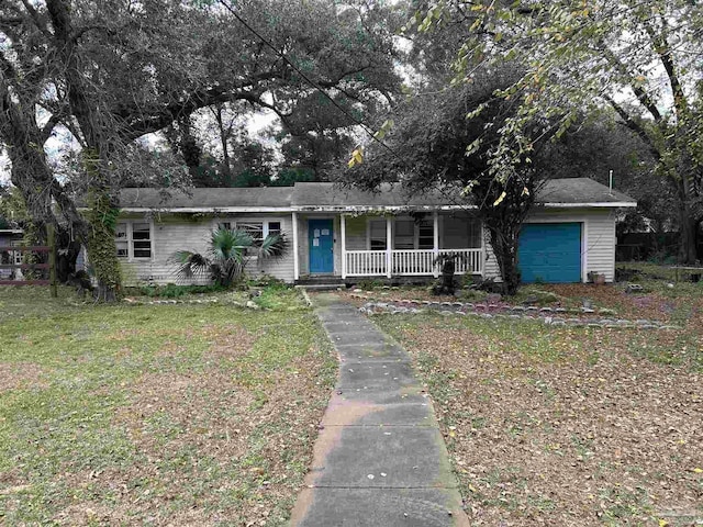 single story home featuring a front yard, a porch, and a garage