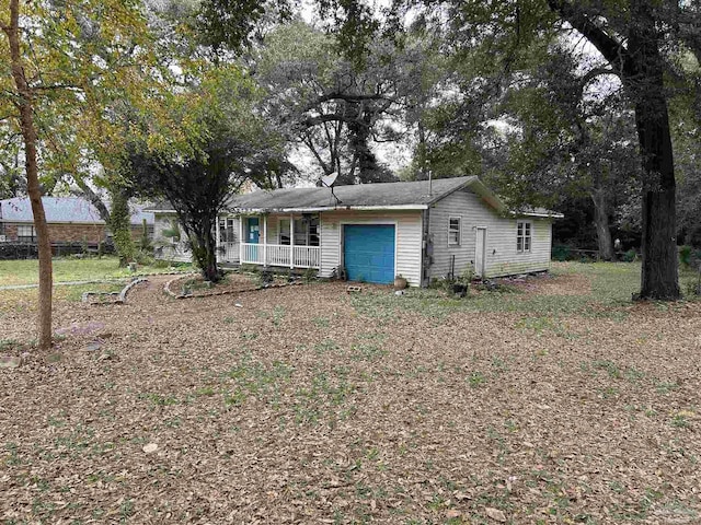 ranch-style home featuring covered porch and a garage