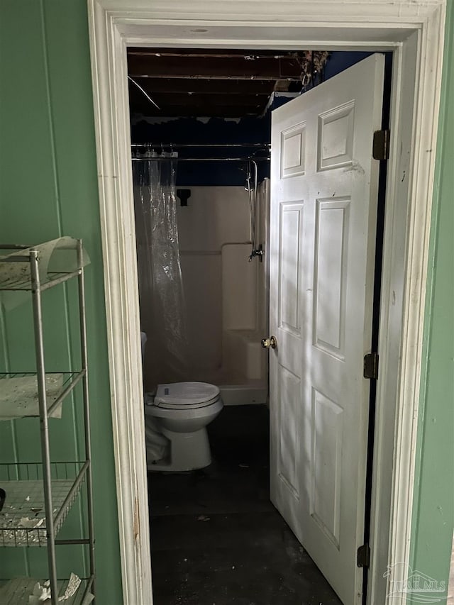 bathroom featuring curtained shower and toilet