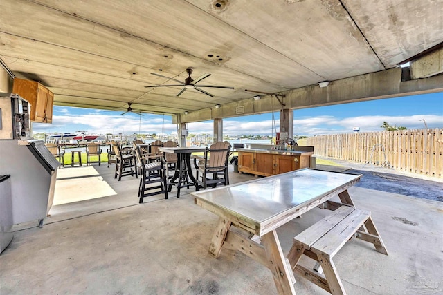 view of patio featuring outdoor dining area, fence, and a ceiling fan