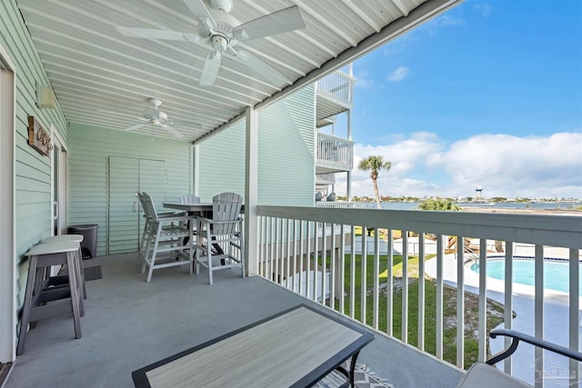 balcony with ceiling fan and a view of the beach