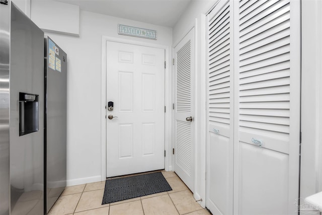 doorway with light tile patterned flooring