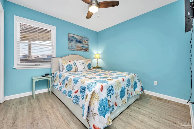 bedroom featuring light wood-style flooring, baseboards, and a ceiling fan