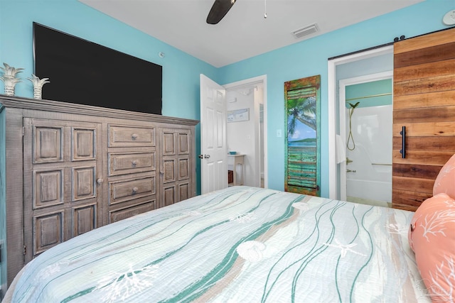 bedroom with ensuite bathroom, ceiling fan, a barn door, and visible vents