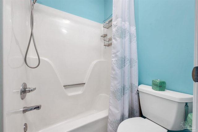 bathroom featuring shower / tub combo with curtain and toilet