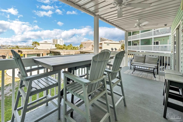 balcony featuring outdoor dining area, ceiling fan, and a patio