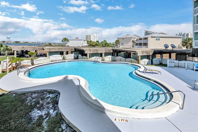 community pool with a patio and fence