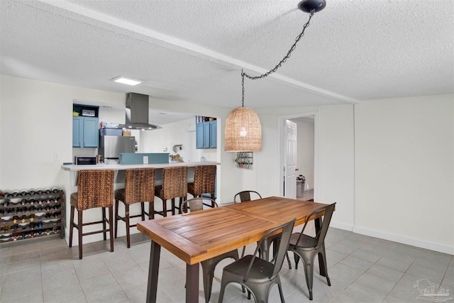 dining space with a textured ceiling and light tile patterned flooring