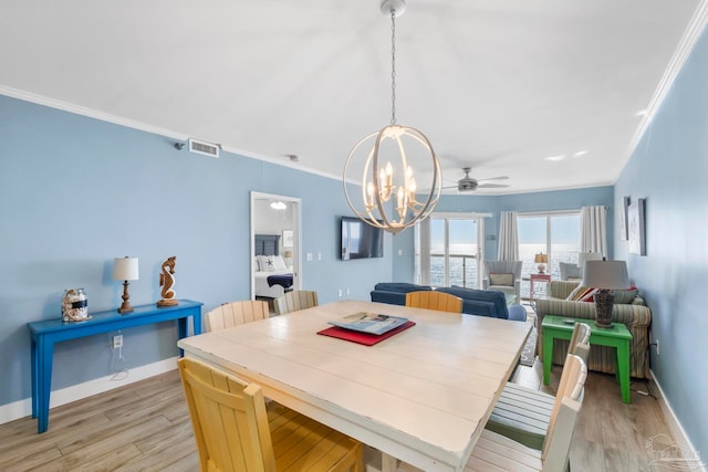 dining space with ceiling fan with notable chandelier, light hardwood / wood-style flooring, and crown molding