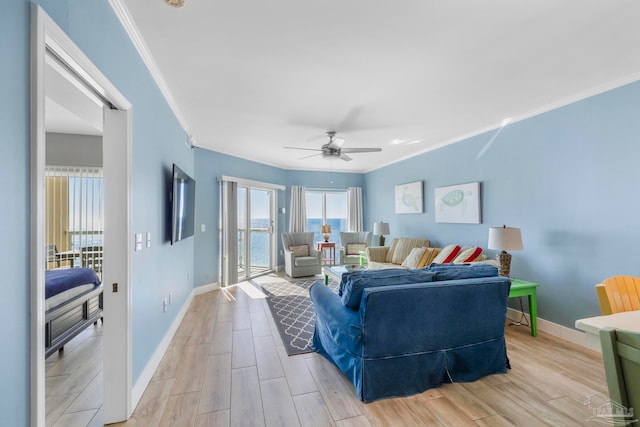 living room featuring light hardwood / wood-style flooring, ceiling fan, and crown molding