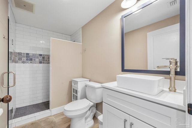 bathroom featuring wood-type flooring, vanity, toilet, and walk in shower