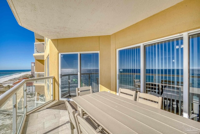 balcony featuring a water view and a beach view