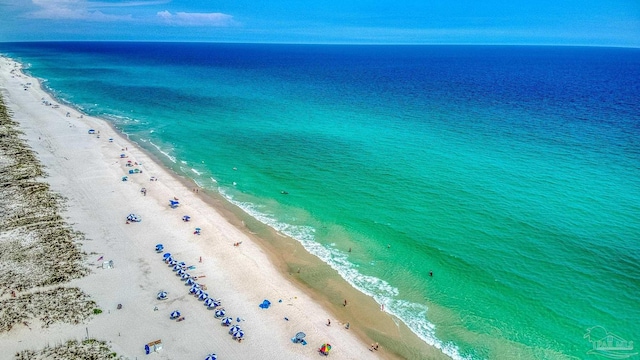 birds eye view of property with a water view and a beach view