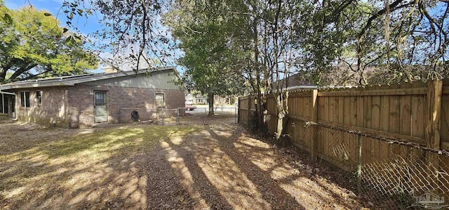 view of yard featuring a fenced backyard and a gate