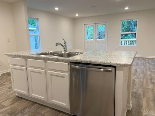 kitchen featuring stainless steel dishwasher, a sink, wood finished floors, white cabinetry, and recessed lighting