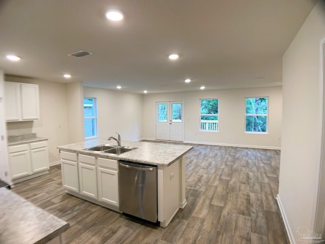 kitchen with a sink, dishwasher, dark wood-style flooring, white cabinetry, and a center island with sink