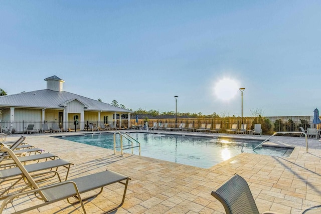 community pool featuring fence and a patio area