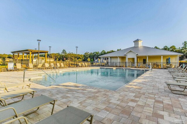 community pool with fence and a patio area