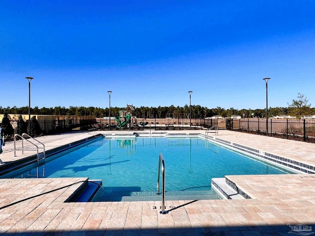 community pool with fence and a patio area