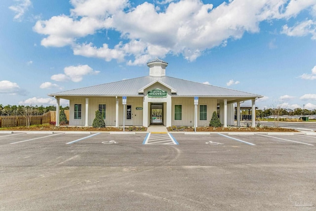 view of building exterior featuring uncovered parking and fence