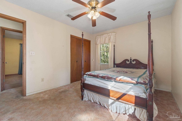 carpeted bedroom with a textured ceiling and ceiling fan