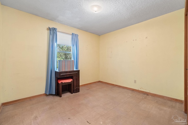 unfurnished room with a textured ceiling