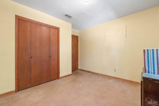 unfurnished bedroom featuring a closet and a textured ceiling