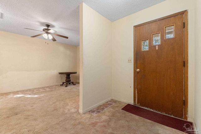 carpeted foyer with a textured ceiling and ceiling fan