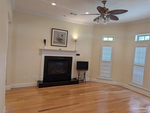 unfurnished living room with crown molding, light wood-type flooring, and a healthy amount of sunlight