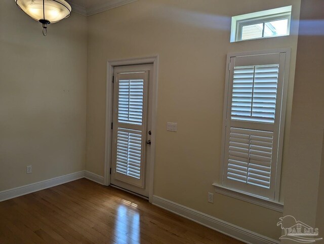 entrance foyer featuring a healthy amount of sunlight, crown molding, and hardwood / wood-style floors