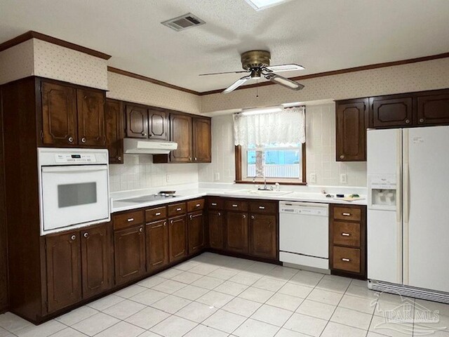 kitchen featuring backsplash, light tile patterned floors, dark brown cabinets, white appliances, and ceiling fan