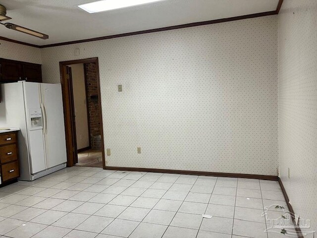 unfurnished dining area with ceiling fan, light tile patterned flooring, and ornamental molding